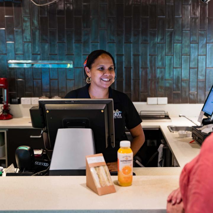 A staff member serving a customer at Mossman Gorge Cultural Centre